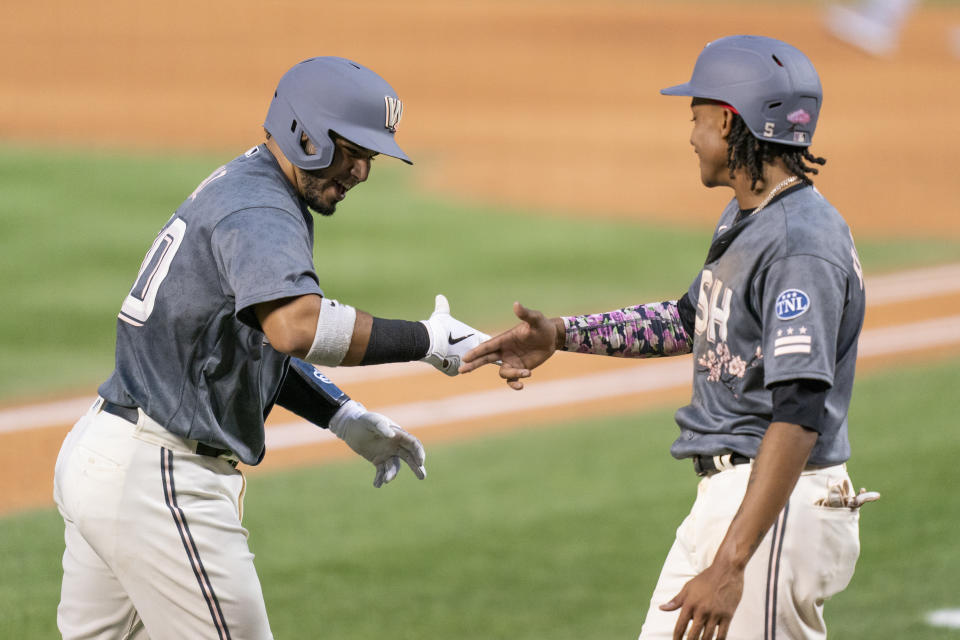 Washington Nationals' Keibert Ruiz, left, celebrates with teammate CJ Abrams, right, after hitting a three-run home run during the first inning of a baseball game against the Los Angeles Dodgers, Friday, Sept. 8, 2023, in Washington. (AP Photo/Stephanie Scarbrough)