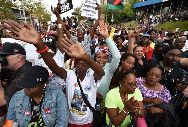 Unos manifestantes gritan consignas contra la brutalidad policial y en memoria de Eric Garner, un hombre negro muerto mientras era arrestado por la policía, el 23 de agosto de 2014 en Staten Island, Nueva York