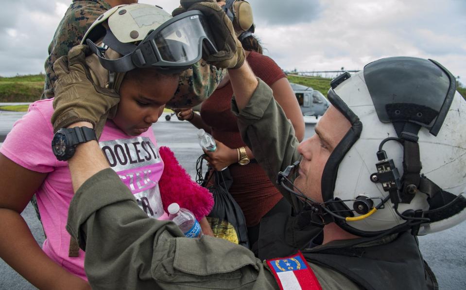 <p>Nicholas Glass, a U.S. Naval Aircrewman, prepares a child for evacuation in Domenica after Hurricane Maria made landfall on September 28, 2017.</p><p><strong>RELATED: </strong><a href="https://www.redbookmag.com/life/mom-kids/news/a17216/work-inspiration-quotes-cosmo/" rel="nofollow noopener" target="_blank" data-ylk="slk:13 Inspiring Quotes to Get You Through Anything;elm:context_link;itc:0;sec:content-canvas" class="link "><strong>13 Inspiring Quotes to Get You Through Anything</strong></a></p>