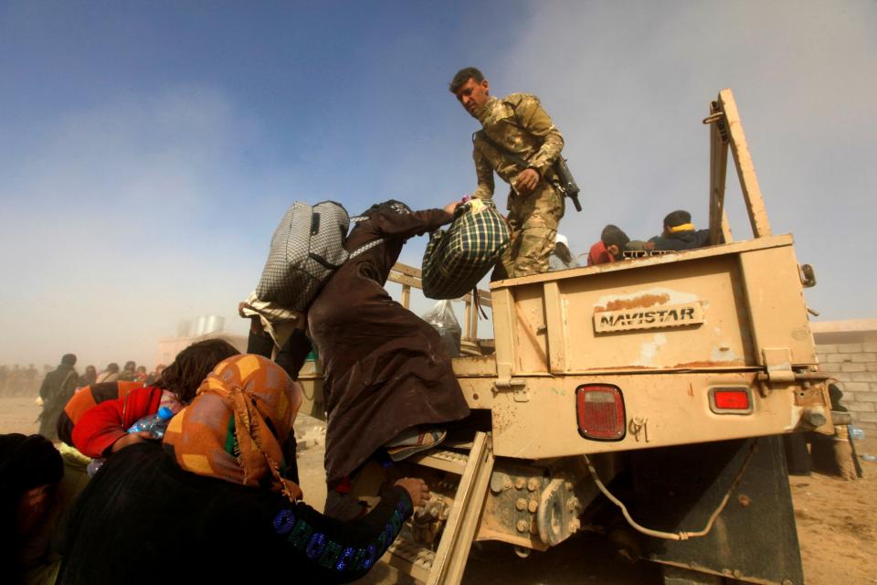 <p>Iraqi soldiers help displaced Iraqis flee their homes as Iraqi forces battle with Islamic State militants, in western Mosul, Iraq February 26, 2017. (Alaa Al-Marjani/Reuters) </p>