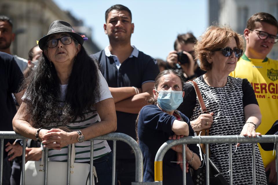 People look at firefighters trying to put out a fire at the Saint-Pierre-et-Saint-Paul cathedral in Nantes, western France, on July 18, 2020. - A blaze that broke inside the gothic cathedral of Nantes on July 18 has been contained, emergency officials said, adding that the damage was not comparable to last year's fire at Notre-Dame cathedral in Paris. "The damage is concentrated on the organ, which seems to be completely destroyed. Its platform is very unstable and could collapse," regional fire chief General Laurent Ferlay told a press briefing in front of the cathedral. (Photo by Sebastien SALOM-GOMIS / AFP) (Photo by SEBASTIEN SALOM-GOMIS/AFP via Getty Images)