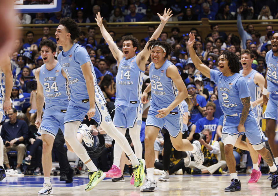 The North Carolina bench runs onto the court to celebrate after beating Duke in an NCAA college basketball game in Durham, N.C., Saturday, March. 9, 2024. (AP Photo/Ben McKeown)