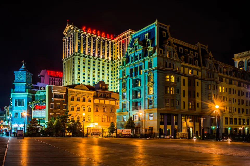 Nighttime view of the Caesar's and Trump Plaza buildings with illuminated signage