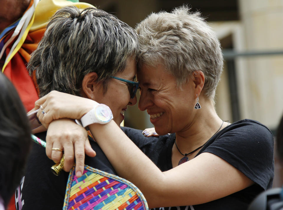 LGBT rights activists Sandra Rojas, left, and Adriana Gonzalez celebrate a Constitutional Court decision to give same-sex couples marriage rights, in front of the Justice Palace in Bogota, Colombia, Thursday, April 7, 2016. (AP Photo/Fernando Vergara)