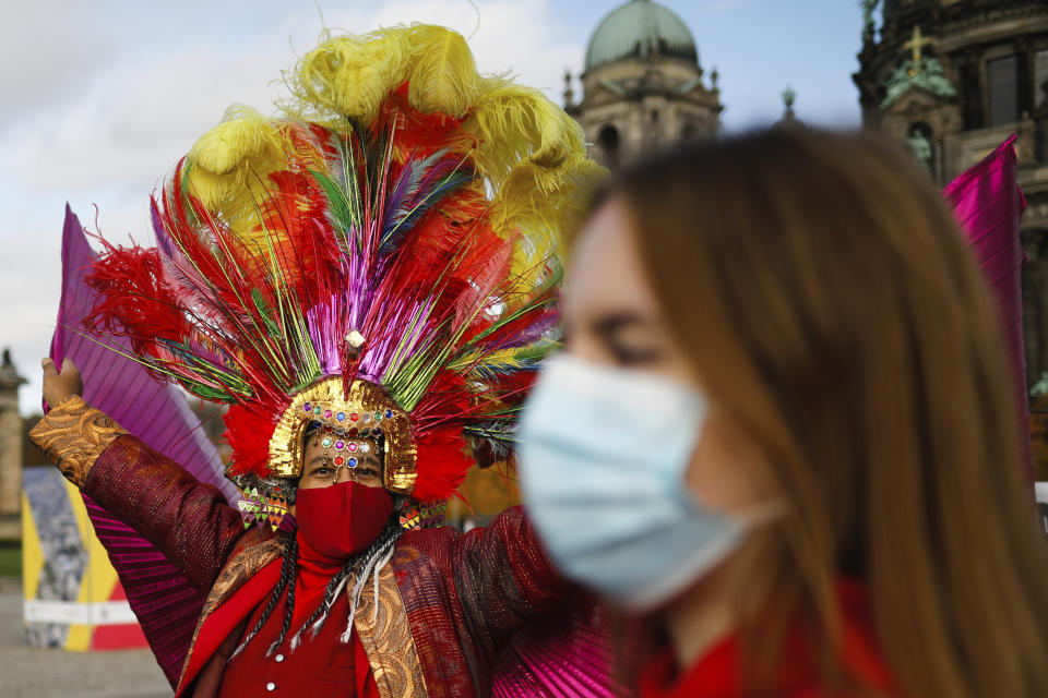 A man in a costume wears a face mask and dances as he attends a protest of people working in the entertainment and entertainment industry against the German government's economic policies to combat the spread of the coronavirus and COVID-19 disease and demand more support for their business, in Berlin, Germany, Wednesday, Oct. 28, 2020. (Photo/Markus Schreiber)