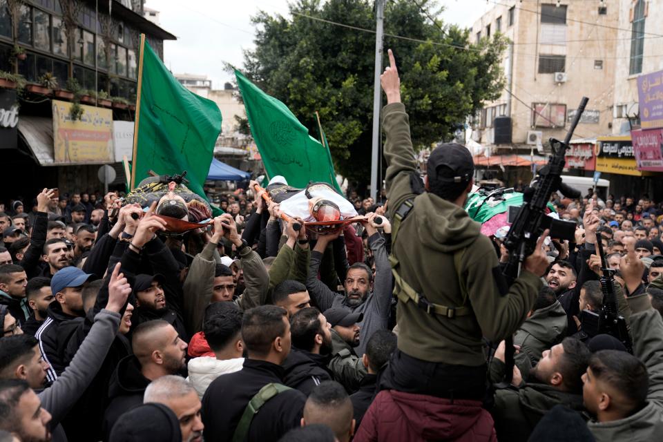 Palestinian gunmen march with bodies of militants killed in an Israeli military raid at Ibn Sina Hospital in the West Bank town of Jenin on Jan. 30, 2024.