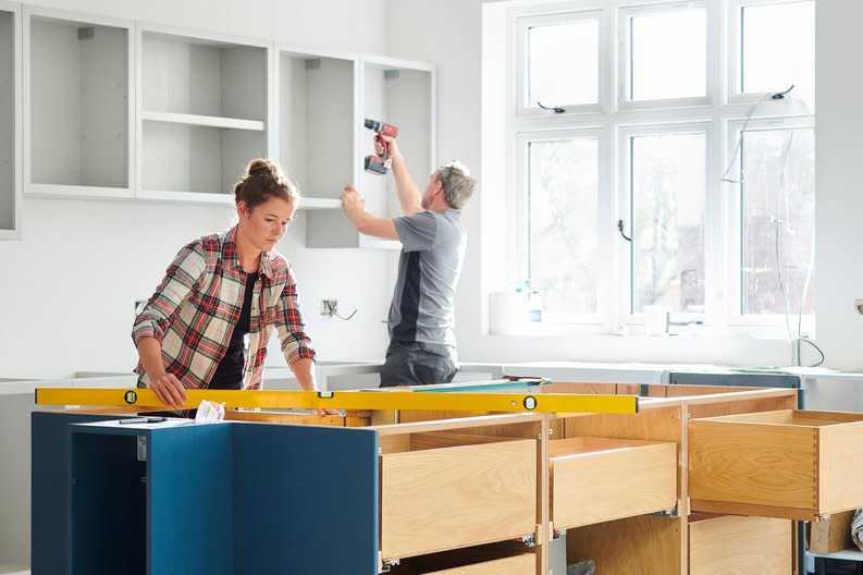 Man and woman working on a kitchen remodel.