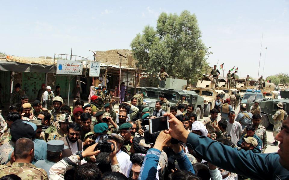 People greet the Afghan security officials as they took control of the Nawa district following an operation against Taliban militants in Helmand earlier this month - Credit: EPA/WATAN YAR