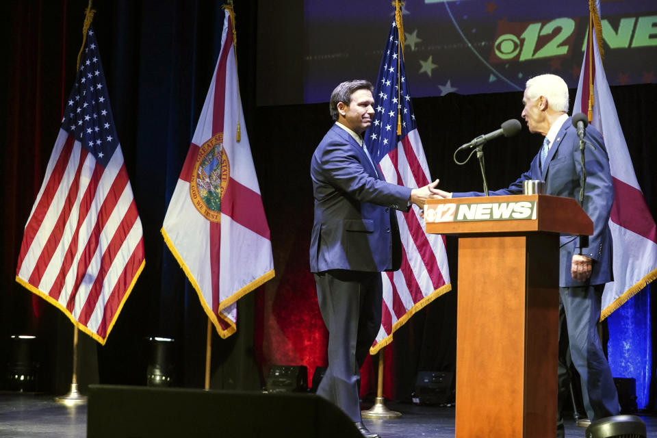 Florida's Republican Gov. Ron DeSantis, left, and his Democratic opponent Charlie Crist take to the stage for their only scheduled debate in Fort Pierce, Fla., Monday, Oct. 24, 2022. (Crystal Vander Weit/TCPalm.com via AP, Pool)