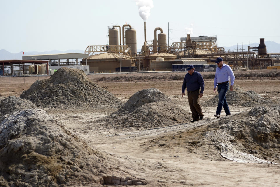 Rod Colwell, CEO of Controlled Thermal Resources, right, and Tracy Sizemore, the company's Global Director of Battery Materials, walk along geothermal mud pots near the shore of the Salton Sea, where the company is mining for lithium, in Niland, Calif., Thursday, July 15, 2021. Demand for electric vehicles has shifted investments into high gear to extract lithium from geothermal wastewater around the dying body of water. The ultralight metal is critical to rechargeable batteries. (AP Photo/Marcio Jose Sanchez)
