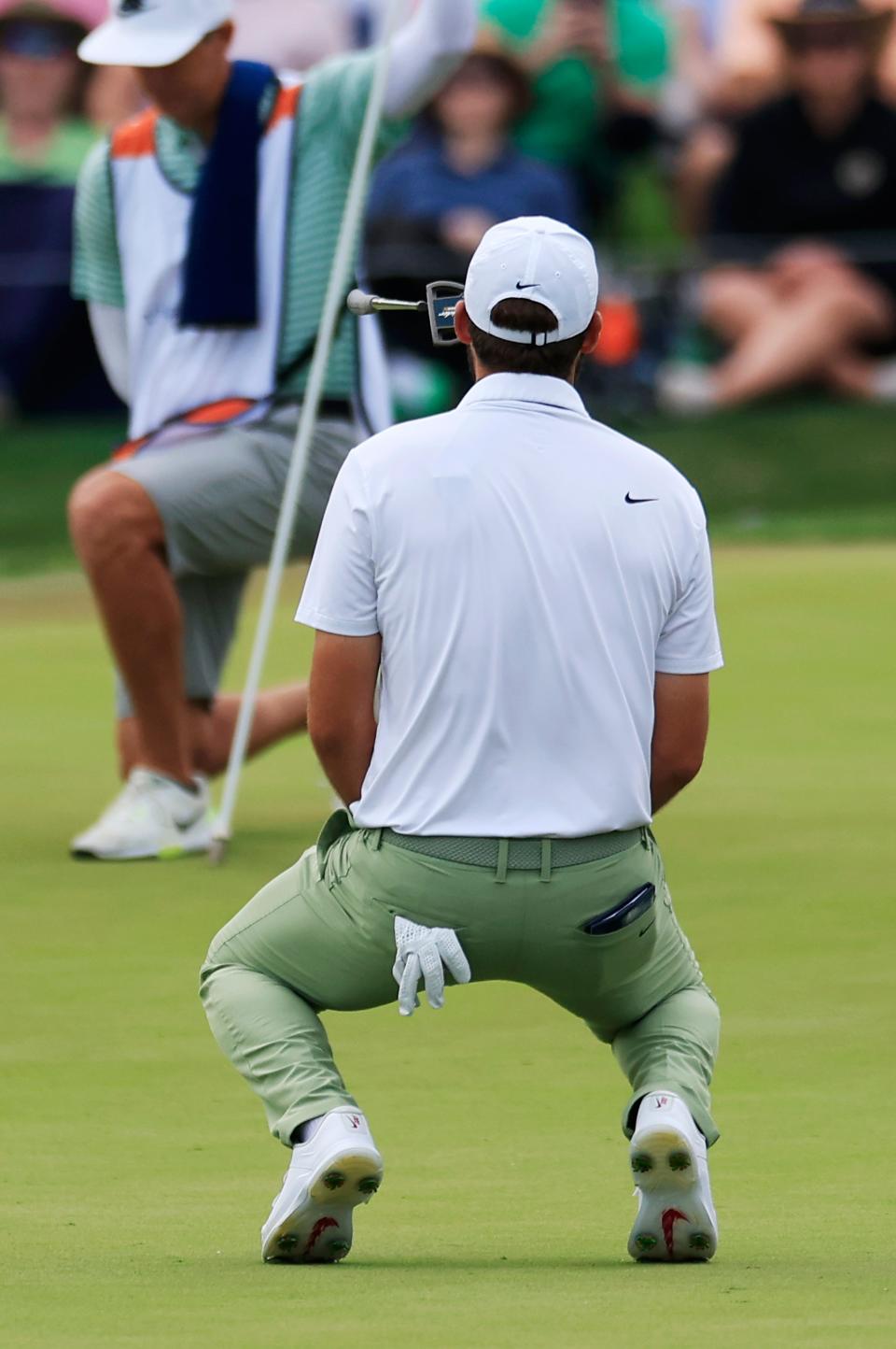 Scottie Scheffler flips his putter after missing a birdie putt on the 18th hole of the final round of The Players Championship on Sunday. But the former Texas Longhorns star held on to win at 20-under par to become the first champion to defend his title in the event's 50-year history.