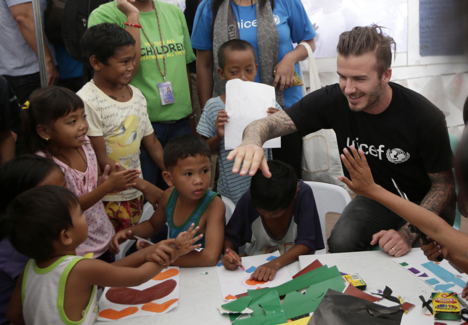 Former England soccer team captain David Beckham interacts with typhoon survivors during his visit to Typhoon Haiyan-hit Tacloban city, central Philippines, Thursday, Feb. 13, 2014. Beckham visited the storm-devastated Philippine city as part of UNICEF's relief efforts. (AP Photo/Bullit Marquez)