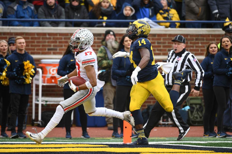 Ohio State wide receiver Chris Olave (17) outruns Michigan defensive back Josh Metellus to the end zone for a touchdown during the first quarter of their 2019 game at Michigan Stadium.