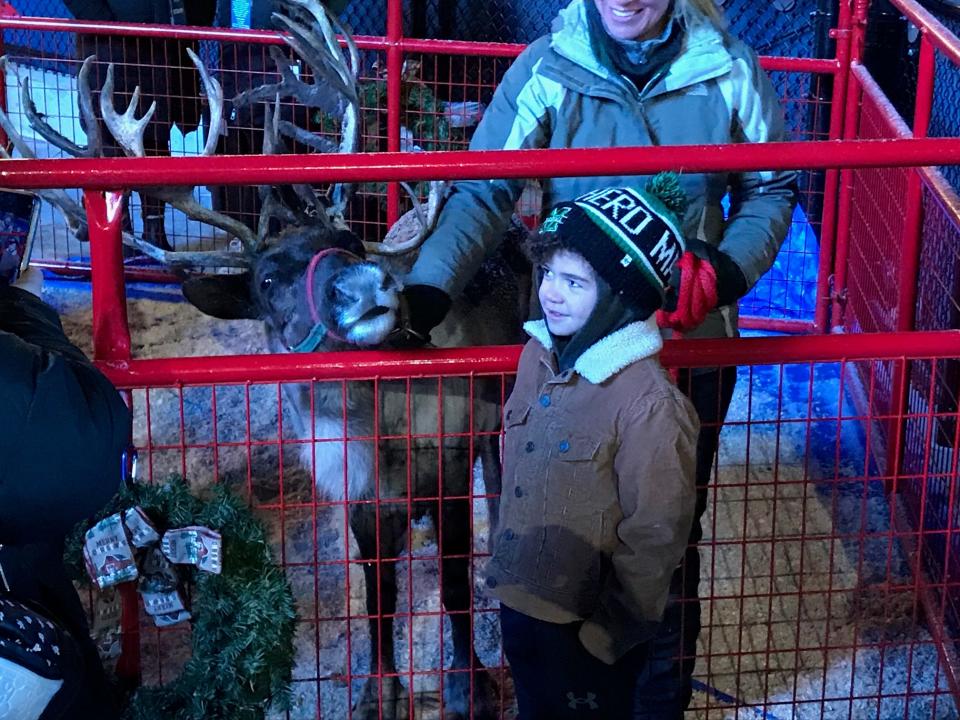 Urijah Manns, 6, of Lake Township, smiles after getting to meet and pet Crystal, a 7-year-old reindeer from Kleerview Farm near Bellville.