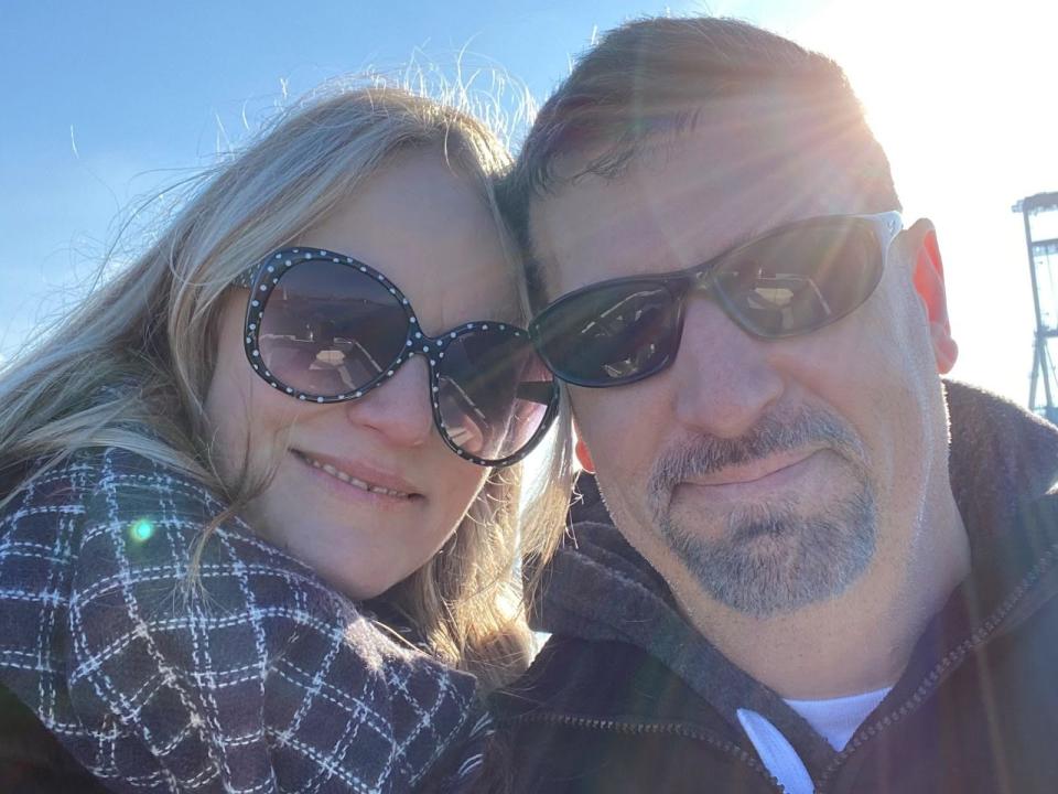 jodi and her partner posing for a selfie together on the dock of their floating home on a sunny day