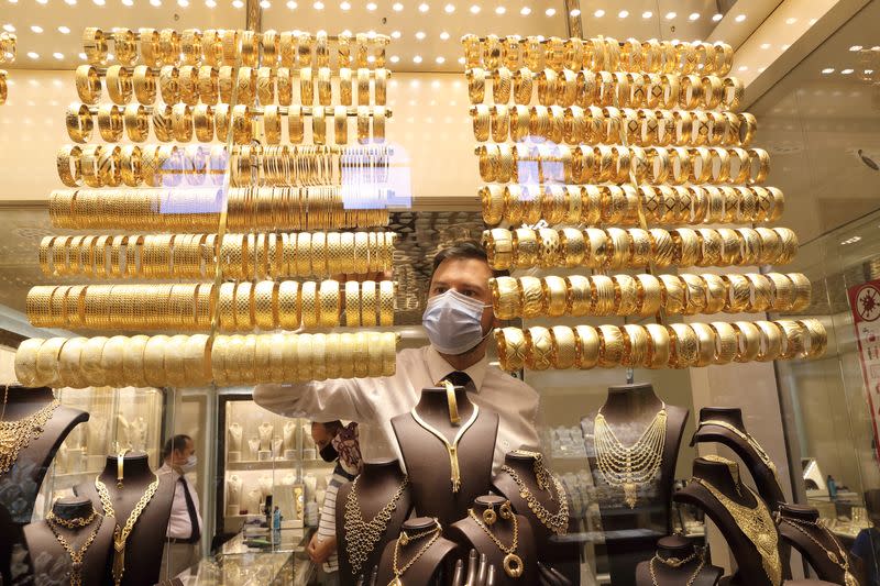 A goldsmith arranges golden bangles at a jewellery shop, in Istanbul