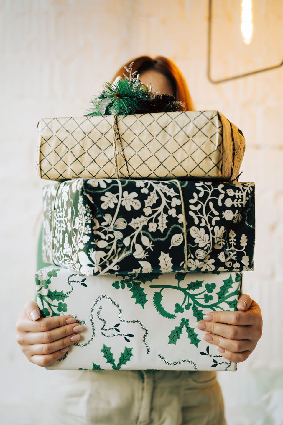 portrait of a long haired red haired woman with gifts packed in white and green boxes christmas holidays, meeting the new year subscription boxes