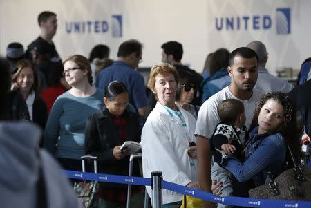 Passengers wait in line to rebook cancelled flights at O'Hare International Airport in Chicago, September 26, 2014. REUTERS/Jim Young