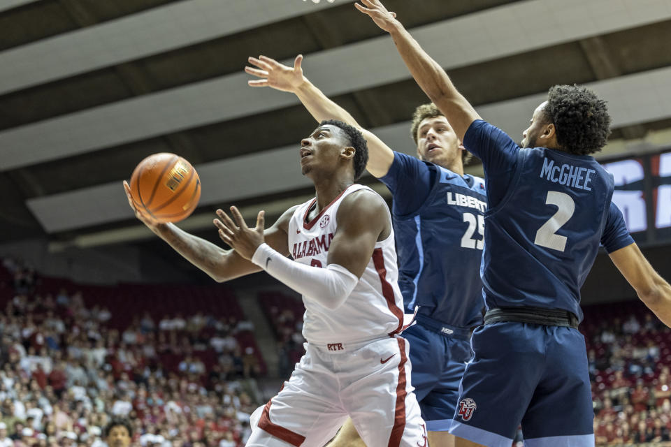 Alabama guard Jaden Bradley (0) gets inside between Liberty forward Zach Cleveland (25) and guard Darius McGhee (2) for a shot during the second half of an NCAA college basketball game, Friday, Nov. 11, 2022, in Tuscaloosa, Ala. (AP Photo/Vasha Hunt)