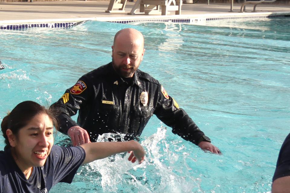 Sgt. Sheldon West with the Amarillo Police Department crosses the water in uniform as he participates in the annual Special Olympics Polar Plunge held at Amarillo Town Club on Hillside Saturday morning.