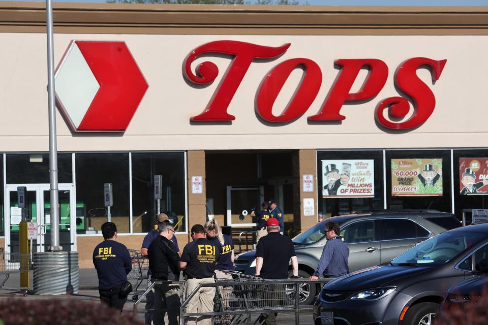 ]Police and FBI agents continue their investigation of the shooting at Tops market on May 15, 2022 in Buffalo, New York.