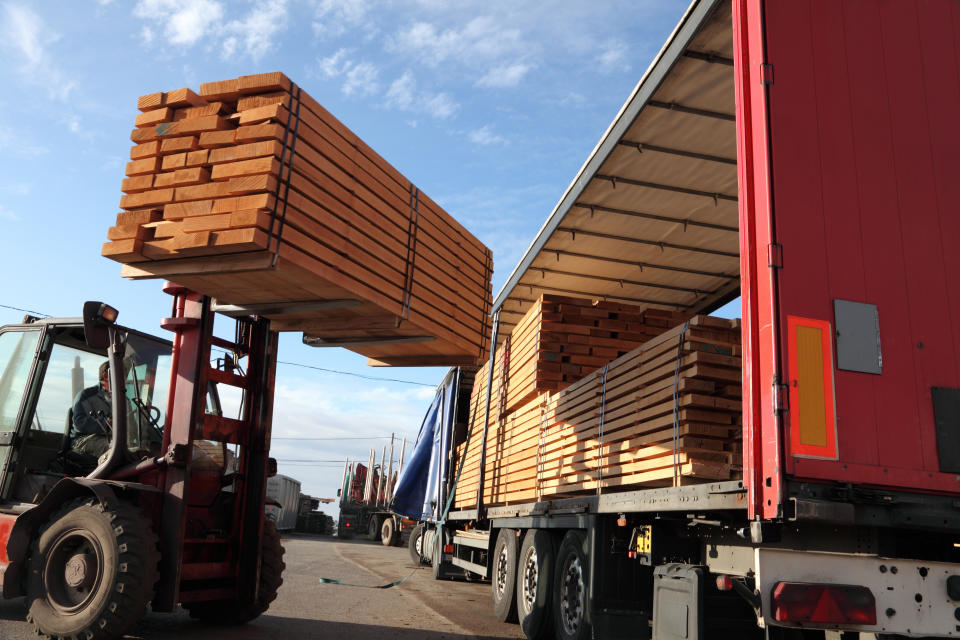 forklift lifting wood onto truck bed