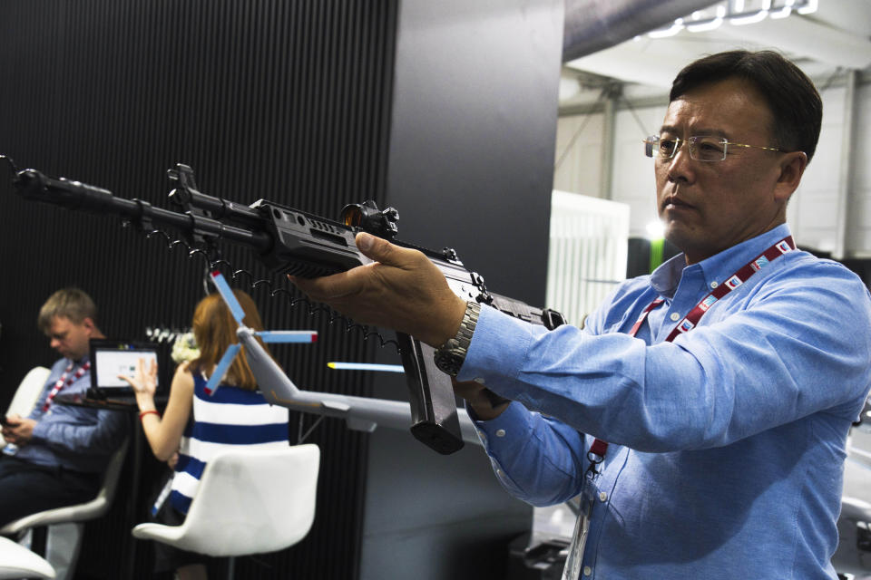 A man handles a Russian-made AK-19 assault rifle at the Dubai Air Show in Dubai, United Arab Emirates, Wednesday, Nov. 15, 2023. The leader of the United Arab Emirates toured the Dubai Air Show on Wednesday as a sanctioned Russian arms supplier displayed an attack helicopter used in its war on Ukraine, highlighting his country's continued ties to Moscow despite Western sanctions targeting it. (AP Photo/Jon Gambrell)