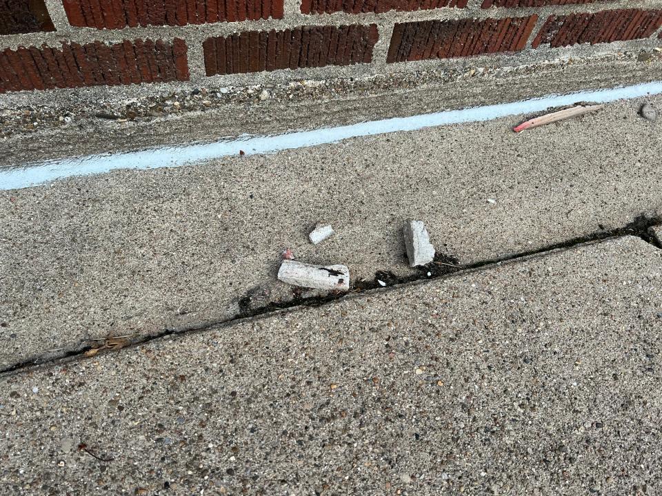 Piece of mortar from the health department building can be seen on the ground.