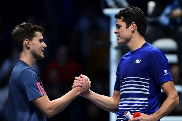 Canada's Milos Raonic (R) shakes hands with Austria's Dominic Thiem after Raonic won their round robin stage men's singles match on day five of the ATP World Tour Finals tennis tournament in London on November 17, 2016