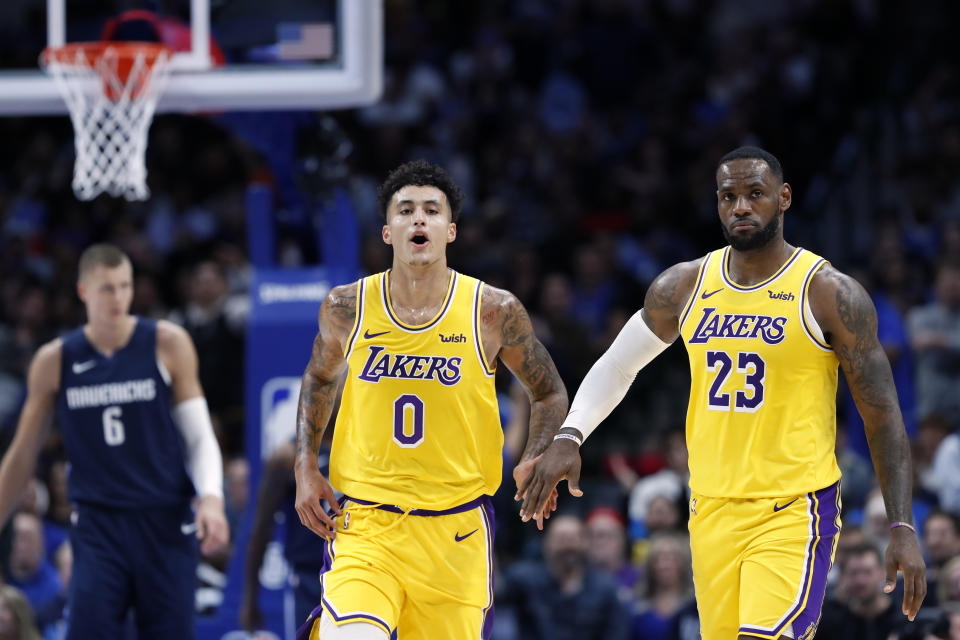 Kyle Kuzma (0) and LeBron James (23) celebrate a basket as Dallas Mavericks' Kristaps Porzingis (6) follows behind during an NBA basketball game in Dallas, Friday, Nov. 1, 2019. (AP Photo/Tony Gutierrez)