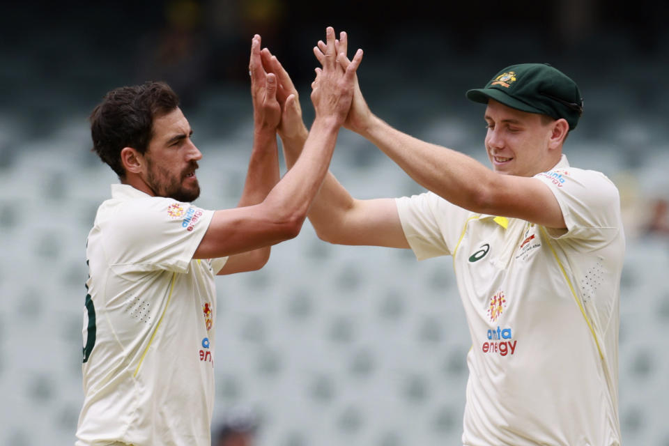 Australia's Mitchell Starc, left, celebrates with teammate Cameron Green after taking the wicket of the West Indies' Devon Thomas on the fourth day of their cricket test match in Adelaide, Sunday, Nov. 11, 2022. (AP Photo/James Elsby)