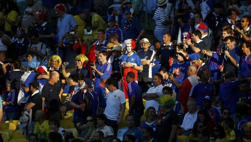 Fans are illuminated by a ray of sunlight on the stands before the 2014 World Cup Group E soccer match between France and Ecuador at the Maracana stadium in Rio de Janeiro June 25, 2014. REUTERS/Kai Pfaffenbach