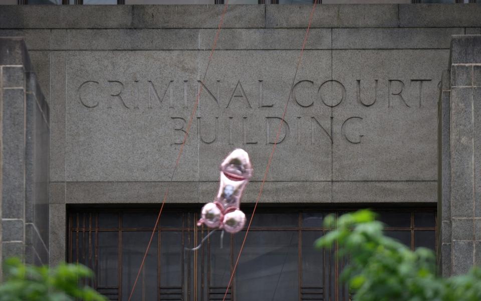 A balloon released by protesters floats by the Manhattan Criminal Court