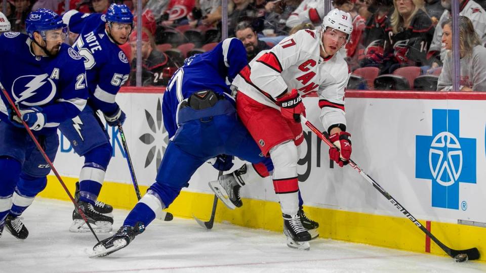 Carolina Hurricanes’ Andrei Svechnikov (37) controls the puck along the board against Tampa Bay’s Haydn Fleury (7) during the first period of an NHL preseason game on Tuesday, September 27, 2022 at PNC Arena in Raleigh, N.C.