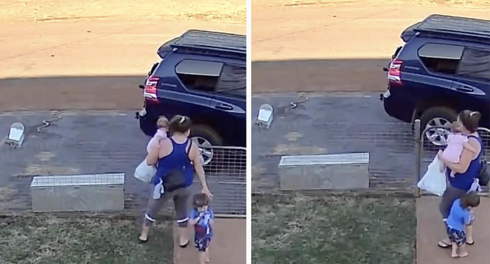 A mum, holding her baby daughter, shields her son from a large snake on their Cloncurry property in North West Queensland.