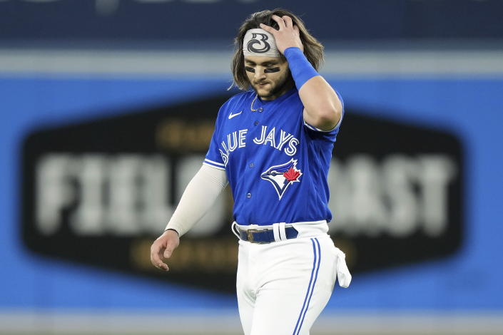 Toronto Blue Jays' Bo Bichette walks back to the dugout after grounding out to end the fifth inning of Game 1 in an AL wild-card baseball playoff series against the Seattle Mariners in Toronto on Friday, Oct. 7, 2022. (Nathan Denette/The Canadian Press via AP)