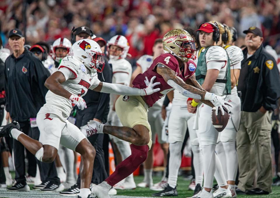 FSU wide receiver Keon Coleman (4) couldn't hang onto the ball under pressure from Louisville's Quincy Riley (3) during first half action as the Louisville Cardinals faced off against the Florida State Seminoles in the 2023 ACC Championship game at Bank of America Field in Charlotte, NC, on Saturday, Dec. 2, 2023.