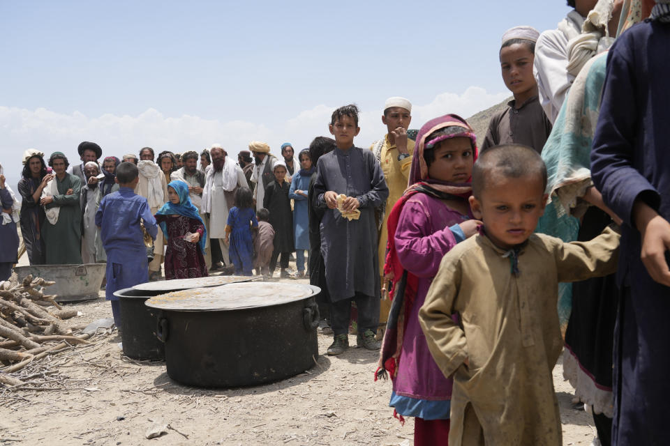 Afghans receive aid at a camp after an earthquake in Gayan district in Paktika province, Afghanistan, Sunday, June 26, 2022. A powerful earthquake struck a rugged, mountainous region of eastern Afghanistan early Wednesday, flattening stone and mud-brick homes in the country's deadliest quake in two decades, the state-run news agency reported. (AP Photo/Ebrahim Nooroozi)