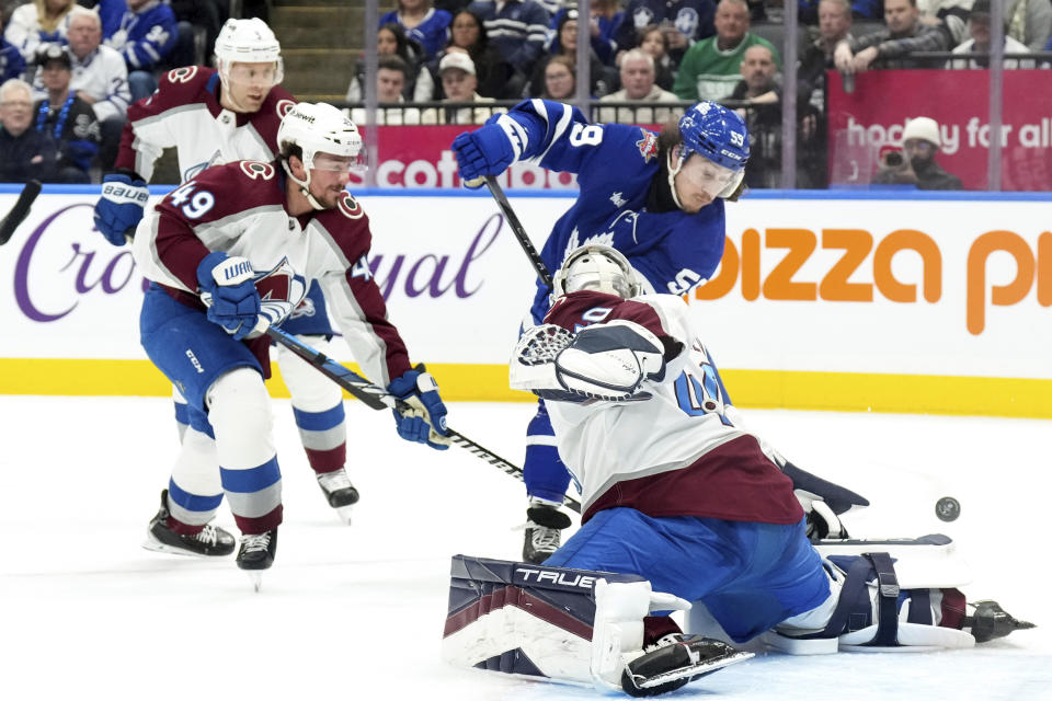 Toronto Maple Leafs left wing Tyler Bertuzzi (59) tries to turn the puck on Colorado Avalanche goaltender Alexandar Georgiev (40) during the second period of an NHL hockey game in Toronto, Saturday, Jan. 13, 2024. (Chris Young/The Canadian Press via AP)