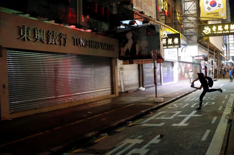 FILE PHOTO: Anti-government protester throws stone at watch retailer in Hong Kong