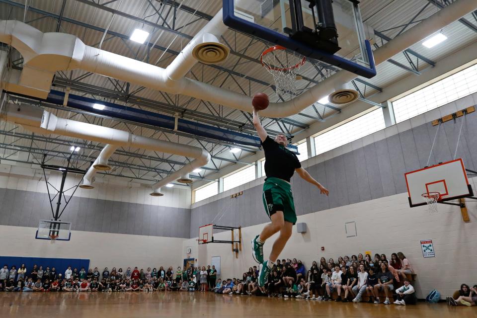 NBA G-League Celtics player, Eric Demers, dunks the ball during his return to Ford Middle School in Acushnet to play a game against teachers and students, before having his jersey hung up at the school.