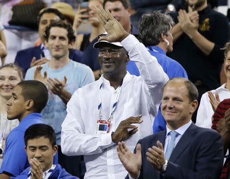 Former basketball great Michael Jordan waves to Roger Federer of Switzerland after Federer defeated Marinko Matosevic of Australia during their men's singles match at the U.S. Open tennis tournament in New York August 26, 2014. REUTERS/Shannon Stapleton