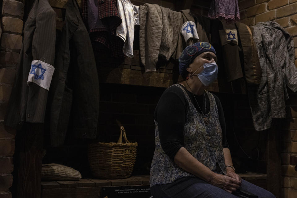 A woman listen to a guide at a reproduction of the headquarters bunker of the Jewish Combat Organization (ZOB) Mila 18 in the Warsaw Ghetto at the museum "From Holocaust to Revival" on the eve of Holocaust Remembrance Day, in Kibbutz Yad Mordechai, Israel, Wednesday, April. 7, 2021. Holocaust remembrance day is one of the most solemn on Israel's calendar with restaurants and places of entertainment shut down, and radio and TV programming focused on Holocaust documentaries and interviews with survivors. (AP Photo/Tsafrir Abayov)