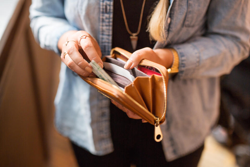 woman taking cash out of her wallet