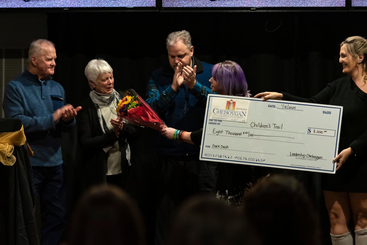 Desiree Dowling and Liz Warner (right), 2023 Leadership Program graduates, join Cheboygan city manager Dan Sabolsky (center) to present an $8,000 check to Dale and Connie Rieger, community volunteers, (left) during the annual Cheboygan Area Chamber of Commerce awards dinner at the Knights of Columbus on Thursday, Jan. 18, 2024. The donation was raised by the 2023 Leadership Cheboygan class through the Duck Dash community event to benefit the Children's Trail.