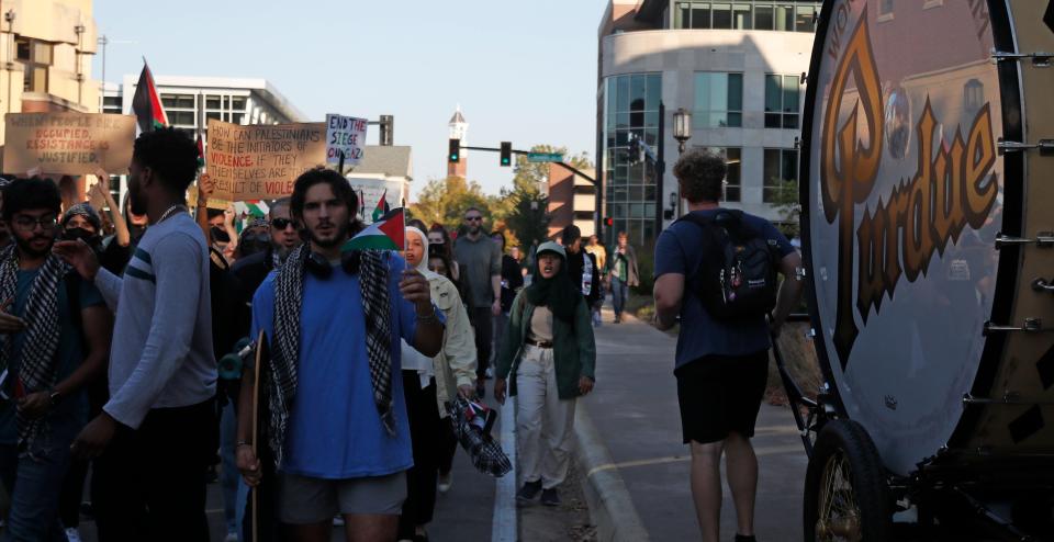 Demonstrators march past the Purdue Big Bass Drum, Thursday, Oct. 12, 2023, at Purdue University in West Lafayette, Ind.