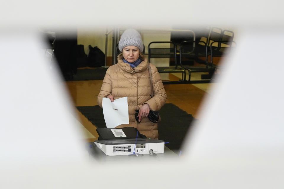 A woman casts a ballot at a polling station during a presidential election in St. Petersburg, Russia, Saturday, March 16, 2024. Voters in Russia are heading to the polls for a presidential election that is all but certain to extend President Vladimir Putin’s rule after he clamped down on dissent. (AP Photo/Dmitri Lovetsky)