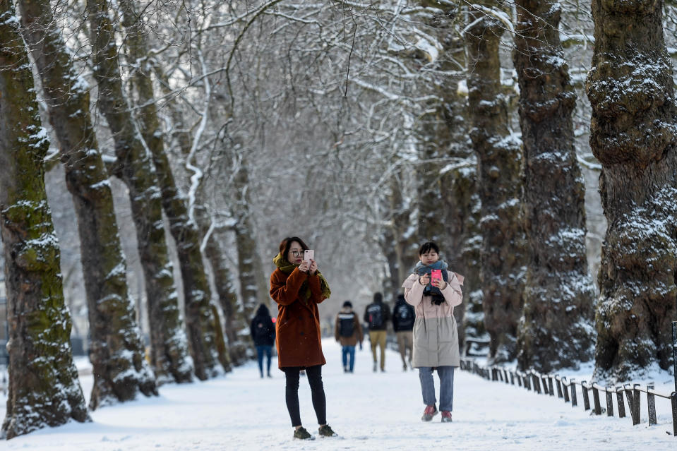<p>Two women take photos in the snow in St James’s Park in London. The wintry weather, dubbed the ‘Beast from the East’ has intensified with lows of -10C (14F). (Reuters/Peter Summers) </p>