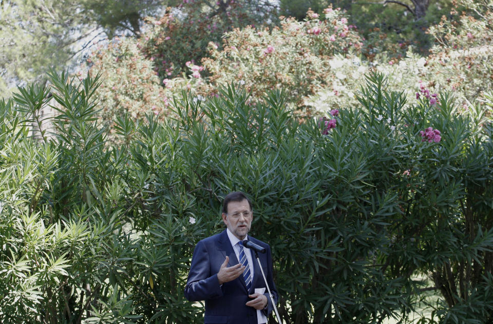 Spanish Prime Minister Mariano Rajoy speaks during a brief news conference in the gardens of the Marivent Palace after meeting with Spain's King Juan Carlos in Palma de Mallorca, Spain, Tuesday Aug. 14, 2012. Spain’s Prime Minister said Tuesday he had still not made a decision on asking for more financial aid for his country and would not until the European Central bank made known plans and conditions for for buying troubled government bonds. (AP Photo/Manu Mielniezuk)