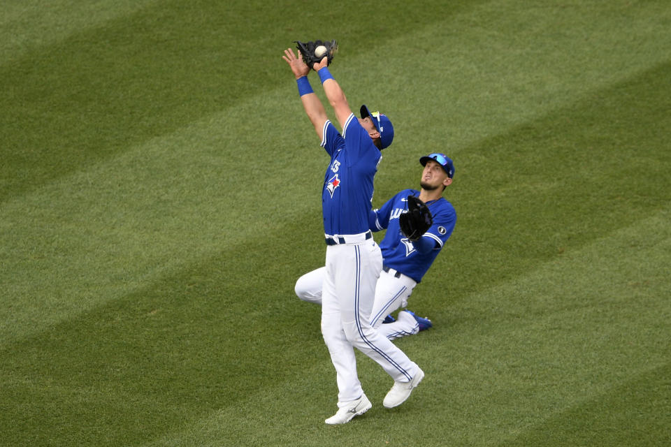 Toronto Blue Jays second baseman Joe Panik, front, makes a catch for the out on a fly ball by Washington Nationals' Adam Eaton during the fourth inning of a baseball game Thursday, July 30, 2020, in Washington. At right is Blue Jays' Cavan Biggio. (AP Photo/Nick Wass)